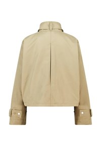 Giacca corta beige con colletto alto, maniche lunghe e dettagli con fibbia sui polsini. Presenta una spaccatura posteriore per la ventilazione. Tessuto liscio.