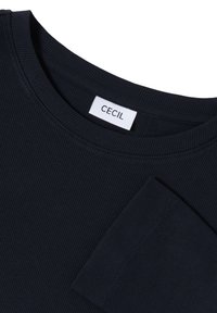 Laivaston sininen ribbikuvioinen pitkähihainen paita, jossa on pyöreä pääntie ja kangaslabeli, jossa lukee "CECiL." Suunnaton pinta, jossa on pieni rintatasku.