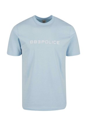 Heledat sinine puuvillane T-särk lühikeste varrukatega, ümmargune kaelus ja valge trükk "883POLICE" rinna peal. Sile tekstuur, igapäevane disain.
