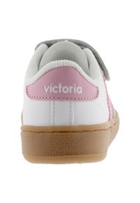 Sneaker bianche con dettagli rosa e fascia grigia. Presenta una suola in gomma testurizzata e cuciture decorative. Logo "Victoria" sul tallone.