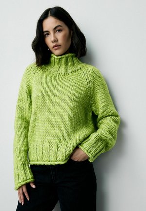 Knitted turtleneck sweater in bright lime green, featuring a chunky ribbed texture, elongated sleeves, and a fitted bottom hem.