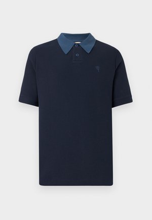 Camisa polo azul marinho com tecido texturizado, colarinho azul claro em contraste e dois botões. Apresenta um pequeno emblema no peito.