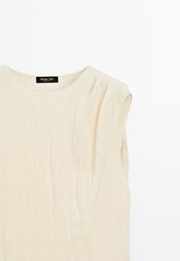 Blouse sans manches de couleur crème avec un col rond et un détail texturé à couches sur l'épaule droite, étiquetée Massimo Dutti.