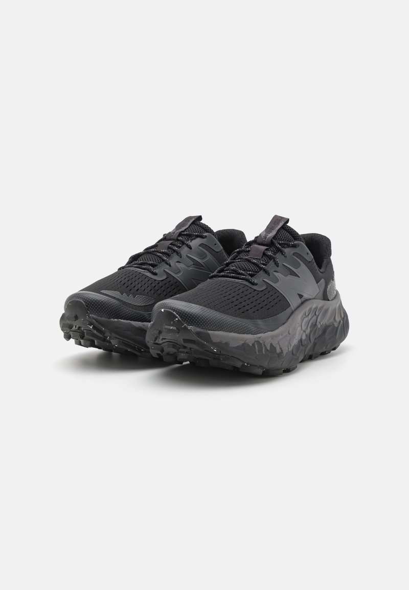 Zapatillas de correr negras con parte superior de malla y suela de goma texturizada. Diseño redondeado, puntera reforzada y sistema de cordones minimalista.