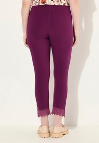 Leggings violettes à la coupe ajustée, avec un détail en dentelle au niveau des chevilles. Tissu lisse avec élasticité pour plus de confort.