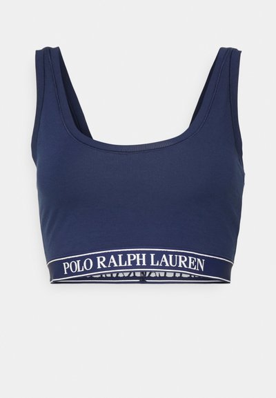 Navy blue crop top bra, made of soft cotton, featuring a wide white logo band at the bottom, with a simple scoop neck design.