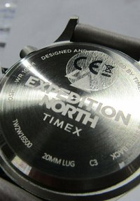 Fond de montre en acier inoxydable avec "Expedition North" et "Timex" gravés. Comprend des marquages pour la résistance à l'eau et la taille des cornes.