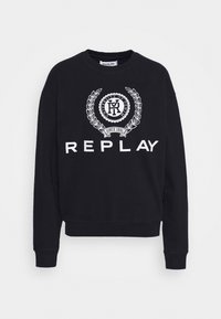 Svart sweatshirt i bomull, med rund hals, ribbade ärmslut och en framträdande vit logotyp med lagerblad på framsidan.