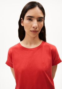 Rode katoenen t-shirt met korte opgerolde mouwen en een ronde hals. Bevat een subtiele geborduurde logo op de linker borst.