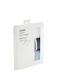 Lot de trois sous-vêtements en coton brésilien en blanc, bleu marine et bleu clair, emballés dans une boîte blanche avec une fenêtre transparente.