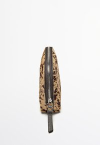 Etui w wzór leopardzi z gładką teksturą futra, czarnym zamkiem błyskawicznym i skórzanym uchwytem. Slim profil, wymiary podkreślające długość kosztem szerokości.