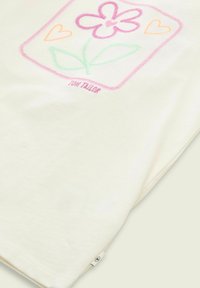 Cremfarbendes T-Shirt mit buntem, gesticktem Blumen- und Herzdesign. Aus weichem Baumwollmaterial mit einem kleinen Logosticker an der Seite.