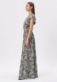 Maks dress w czarno-białym wzorze liści, z falbaniastymi rękawami, marszczonym talią i zwiewnym materiałem. Gładka tekstura.