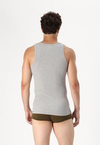 Top sin mangas gris con canalé, diseño ajustado y material de algodón, combinado con bragas verdes olivo, visto desde la parte de atrás.