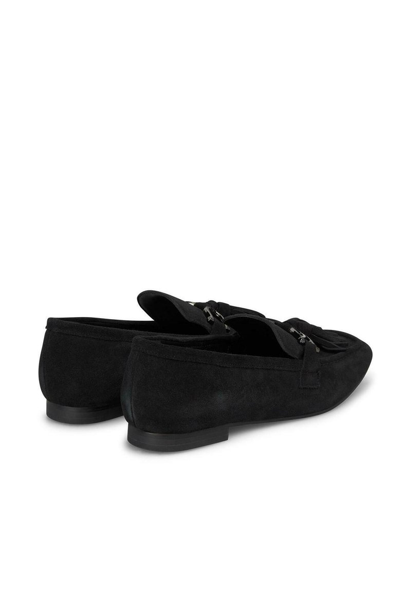 Mocasines de ante negro con una textura suave, diseño tipo slip-on y acentos decorativos de hebilla, con una suela de goma baja y plana.