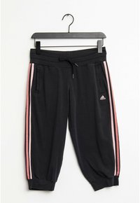 Schwarze Sportpants aus weichem Material, mit pinken Seitestreifen, elastischem Bund, Kordelzug und gerippten Säumen. Mit Fronttaschen.