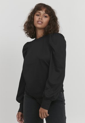 Felpa nera con maniche a palloncino, scollatura rotonda e polsini a costine. Realizzata in tessuto morbido, progettata con una vita aderente e una silhouette rilassata.