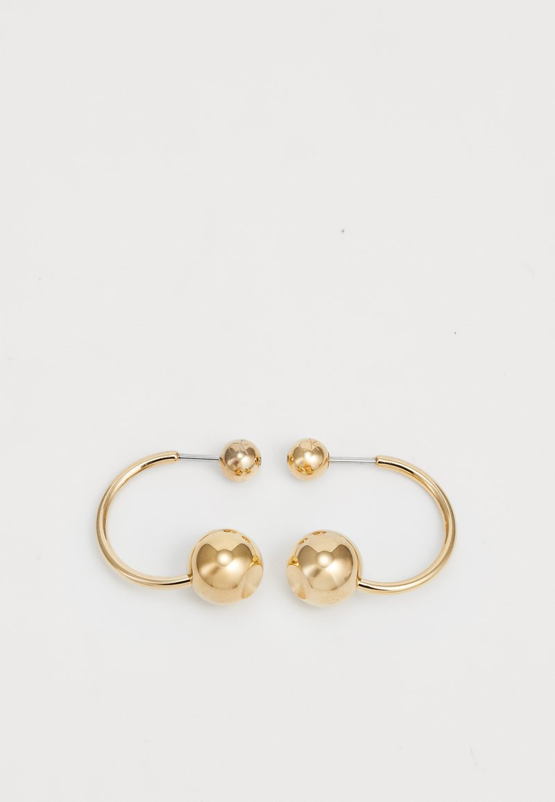 Orecchini in metallo color oro con un design circolare che presenta due sfere: una più grande e testurizzata e una palla più piccola e lucida nella parte superiore.