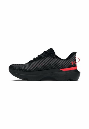 Schwarze Sportschuhe mit strukturiertem Mesh-Obermaterial, akzentuiert mit roten Details, ausgestattet mit einer gepolsterten Sohle und einem schlanken, modernen Design.