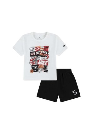 T-shirt bianca a maniche corte con grafiche testuali motivazionali multicolori Nike abbinata a pantaloncini neri con loghi Nike bianchi.
