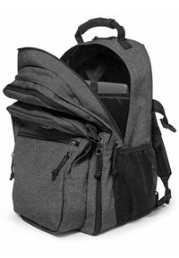 Mochila de tela gris con múltiples compartimentos con cremallera, un interior acolchado para un portátil y bolsillos laterales de malla para almacenamiento adicional.