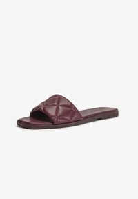 Sandale plate à bout ouvert avec une large bride matelassée en cuir bordeaux foncé et une semelle fine.