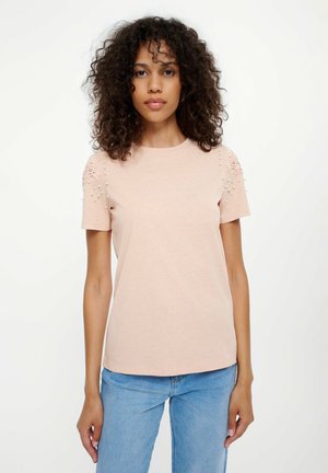 Jasnoróżowa koszulka z krótkim rękawem z teksturowanymi akcentami na ramionach, haftem i perłami. Wykonana z miękkiej bawełny, o luźnym kroju.