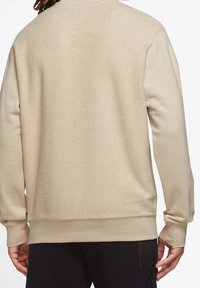 Beige sweatshirt med strukturerad yta, långa ärmar och ribbade manschetter och nederkant. Inga synliga logotyper eller prydnader på baksidan.