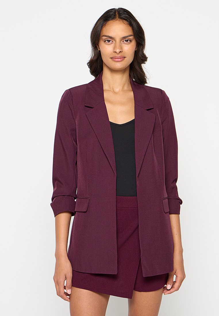 Bordeaux op maat gemaakte blazer met een enkele knop, reverskraag en omgeslagen mouwen, gemaakt van lichte stof. Eenvoudig, gestructureerd ontwerp.