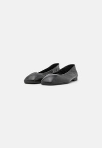 Ballers en cuir noir avec un bout arrondi, texture lisse et design bas, dotées d'un doublure douce et d'un matériel minimal.