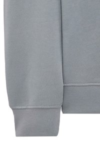 Grå sweatshirt detalj med en jevn tekstur, ribbede mansjetter og et rent, enkelt design med tonalt søm.