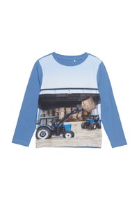Langsleeve blauwe t-shirt met een fotoprint van blauwe tractors en hooibalen met een textuurafwerking. Zacht katoen met een rond decolleté ontwerp.