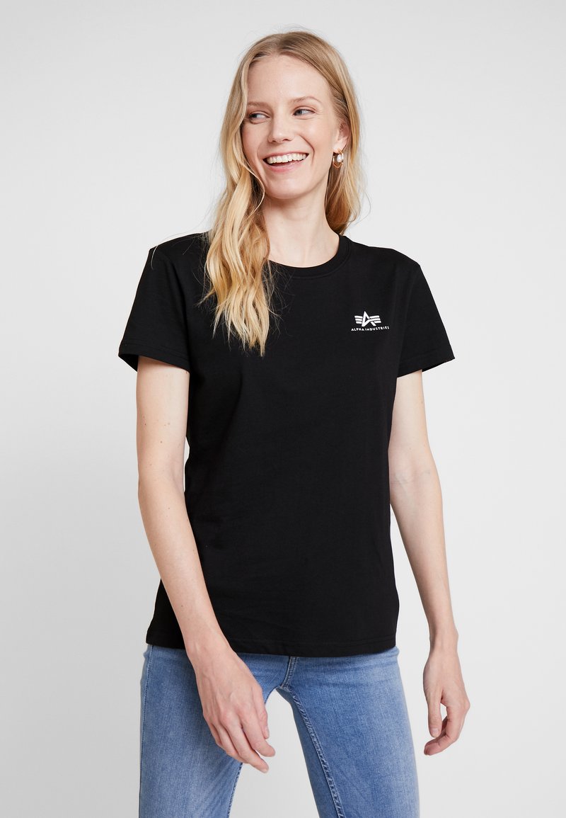 Schwarzes Baumwoll-T-Shirt mit kurzen Ärmeln, rundem Halsausschnitt und einem weißen Logo, das auf der linken Brustseite aufgedruckt ist. Lässige Passform.