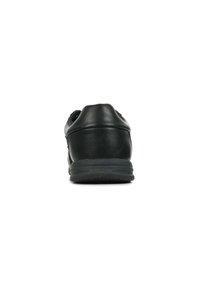 Zapato deportivo negro con tacón redondeado, parte superior de cuero texturizado y suela de goma que presenta un patrón de relieve para mayor agarre.