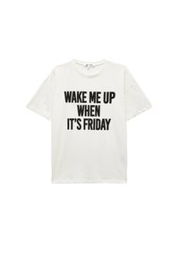 Hvid bomuld t-shirt med korte ærmer, prydet med fed sort tekst: "VÆK MIG NÅR DET ER FREDAG." Rund halsudskæring og afslappet pasform.