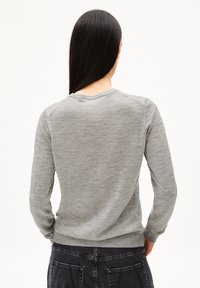 Grauer Langarmpullover aus weichem Strickmaterial, mit rundem Halsausschnitt, gerippten Bündchen und einem taillierten Saum.