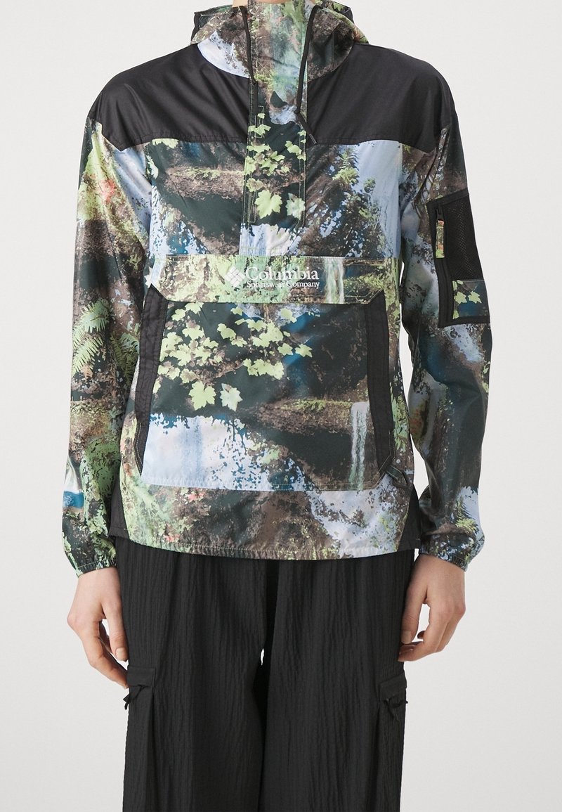 Giacca leggera e colorata con cappuccio, stampa ispirata alla natura che presenta tonalità di verde, marrone e nero; include una tasca frontale e polsini elastici.