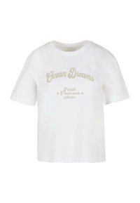 Balta medvilninė marškinėliai su apvaliu kaklu, trumpomis rankovėmis ir spausdinta užrašu: "Ocean Dreams" ir "Norėčiau, kad būčiau padaręs daugiau nuotraukų" smėlio spalvos.