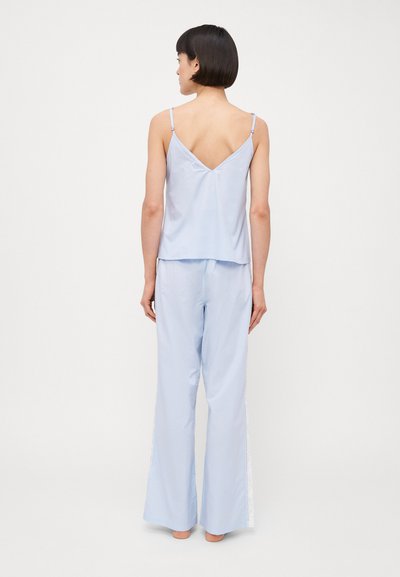 Light blue pajama set featuring a V-neck camisole with thin straps and wide-leg pants with lace trim along the side seams.