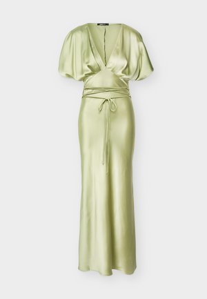 Φωτεινό πράσινο φόρεμα από σατέν μέχρι το πάτωμα με βαθύ V-λαιμόκοψη, φουσκωτά μανίκια και λεπτή ζώνη που δένει γύρω από τη μέση.