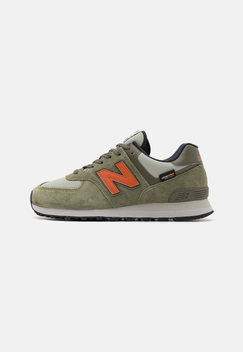 Des baskets en suède vert et gris avec un logo 'N' orange, un revêtement texturé, un design à lacets et une semelle en caoutchouc noir avec adhérence.