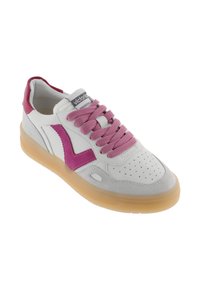 Baskets en cuir blanc avec des accents roses, présentant un panneau en daim texturé, un bout perforé et des lacets roses. Semelle en caoutchouc transparente.