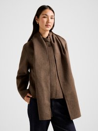 Rudos vilnos mišinio švarkas su struktūrizuotu dizainu, turintis vieną užsegamą sagą, šonines kišenes ir ilgą, laisvai krintantį šaliką.