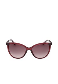 Gafas de sol con montura transparente color burdeos en forma de ojo de gato, lentes degradados y varillas negras delgadas. Presentan un acabado liso y brillante.