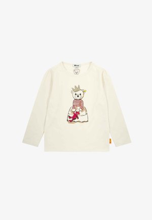Long-sleeve cream shirt featuring a bear illustration with a crown, striped top, and red toy. Soft cotton fabric with a rounded neckline.