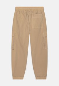 Beige cargo bukser med elastisk talje og manchetter, der har en baglomme og to sidelommer med klap.