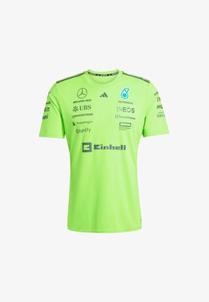 Zelené sportovní tričko s krátkým rukávem, kulatým výstřihem a více sponzorskými logy výrazně vytištěnými na přední části a rukávech.