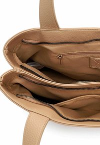 Borsa tote in pelle beige con esterno testurizzato. L'interno presenta due scomparti con chiusure a cerniera e una piccola tasca con cerniera.