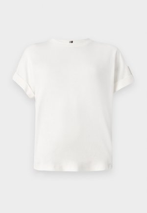 T-shirt blanc à manches courtes avec un col rond et des poignets roulés, en tissu doux, arborant un discret accent de logo près de l'ourlet.