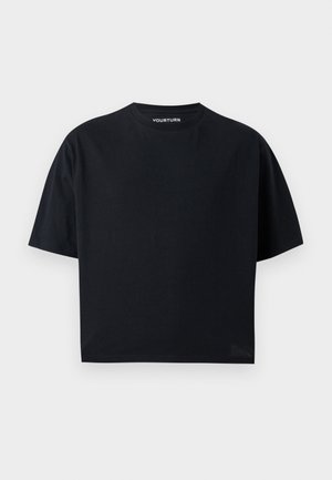 Μαύρο t-shirt με κοντά μανίκια και στρογγυλή λαιμόκοψη, σε χαλαρή γραμμή, απεικονιζόμενο σε απλό ανοιχτό γκρι φόντο.